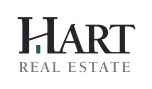 Logo for Hart Real Estate with HART in large black uppercase letters and a small green rectangle forming part of the H. REAL ESTATE is written below in smaller, gray uppercase letters. The background is light gray.