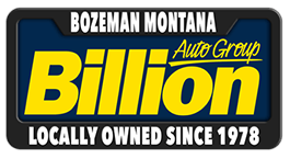 License plate-style logo for Billion Auto Group in Bozeman, Montana, with bold yellow text and the phrase Locally Owned Since 1978 at the bottom.